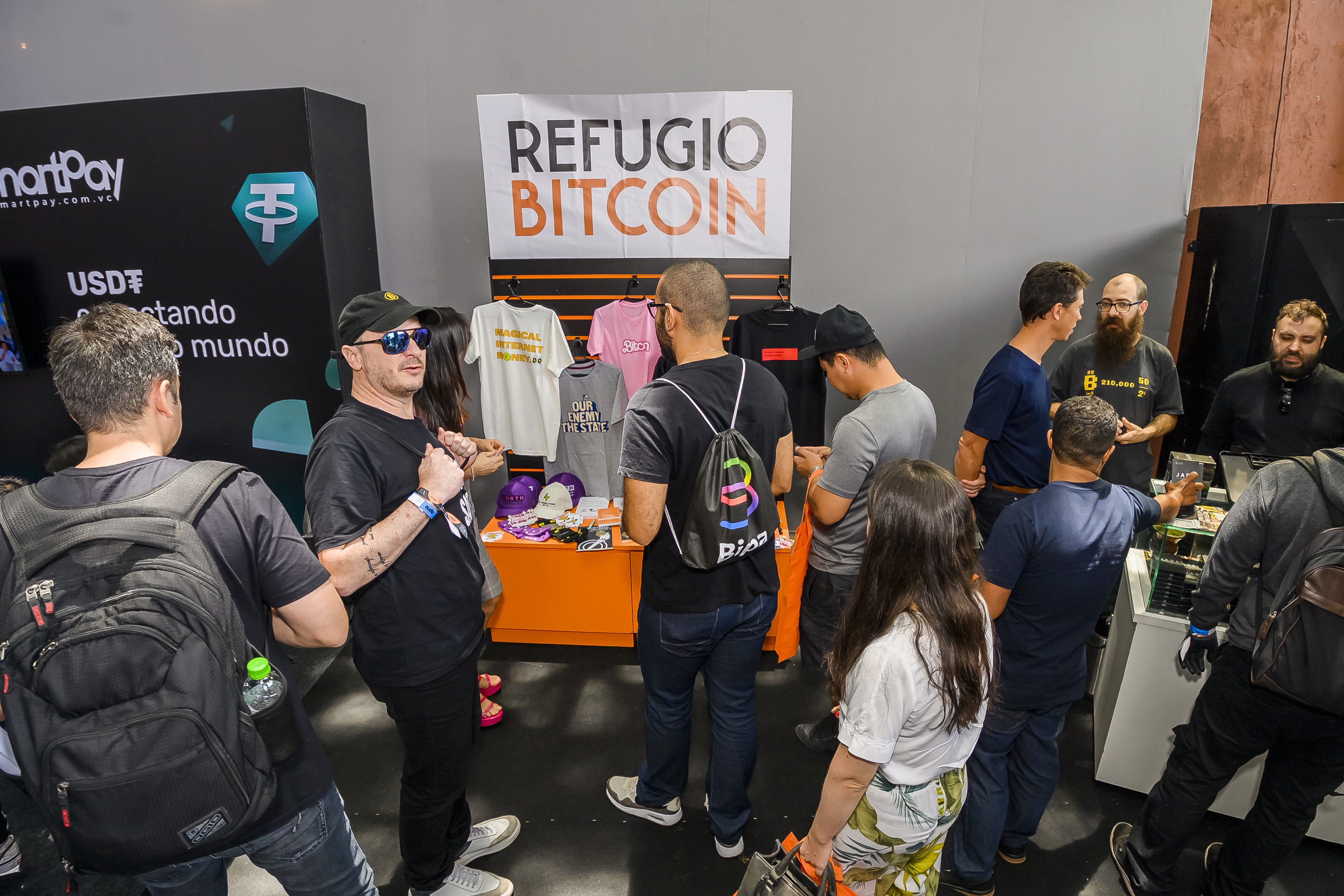 Pessoas em volta da feira Refugio bitcoin na satsconf