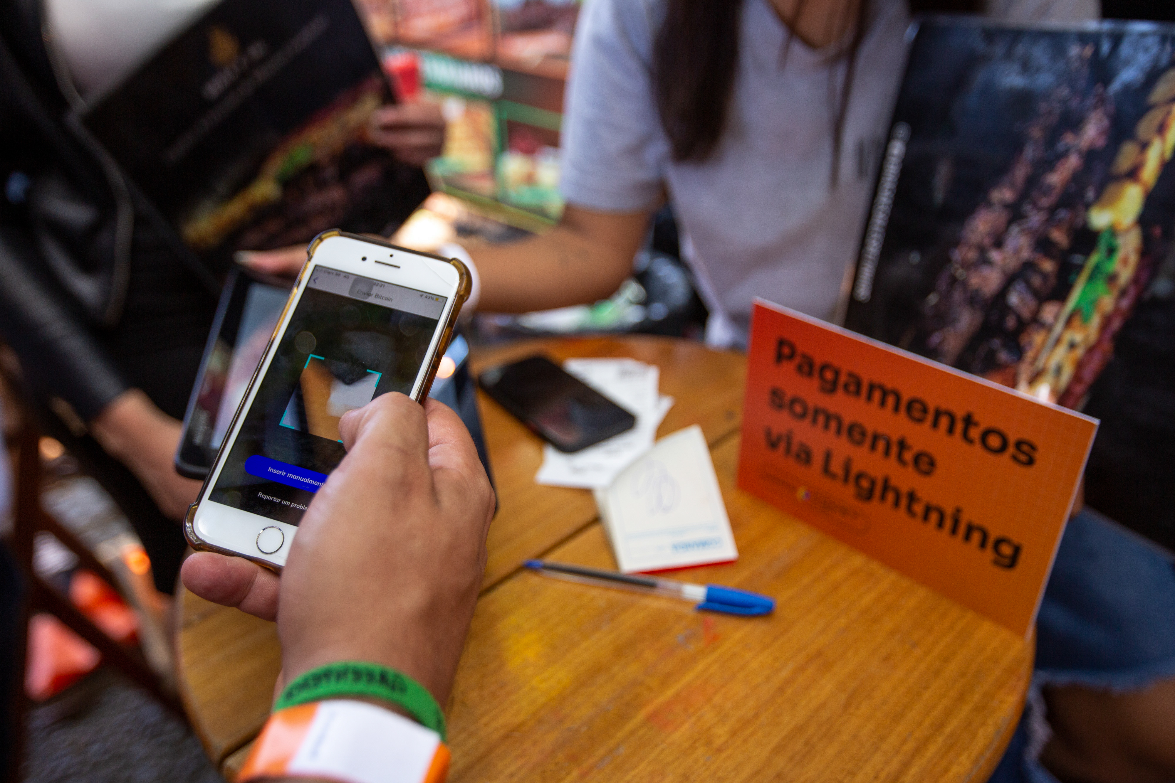 Homem segurando um iphone fazendo pagamento em lightning